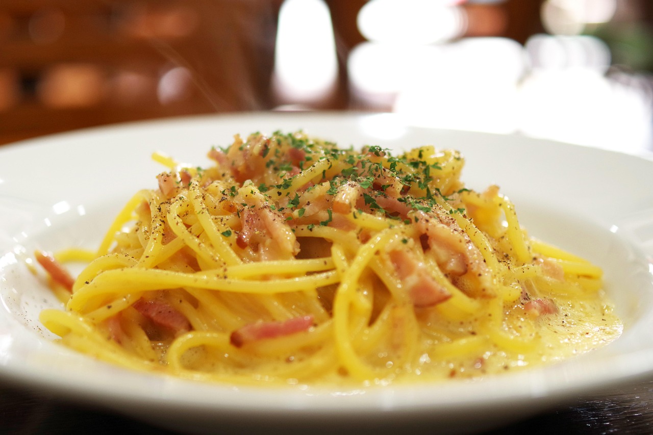 Pasta alla carbonara cremosa con guanciale e formaggio, presentata in un piatto elegante.