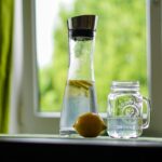 Un bicchiere d'acqua su un tavolo, simbolo dell'importanza di idratarsi quotidianamente.